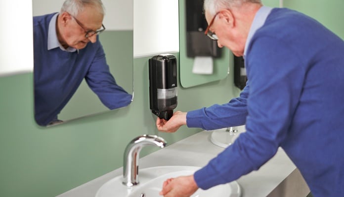 Ein älterer Mann wäscht sich die Hände