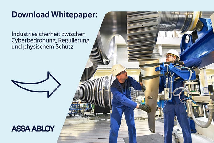 Zwei Industriearbeiter in Schutzkleidung montieren mit einer Maschine ein großes Metallbauteil in einer Produktionshalle; daneben Hinweis „Download Whitepaper: Industriesicherheit zwischen Cyberbedrohung, Regulierung und physischem Schutz“ von ASSA ABLOY.
