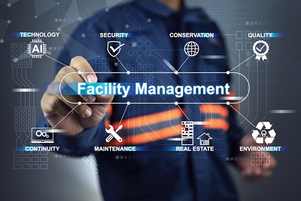 Person points to a digital diagram titled 'Facility Management' with icons for technology, security, conservation, quality, continuity, maintenance, real estate, and environment.
