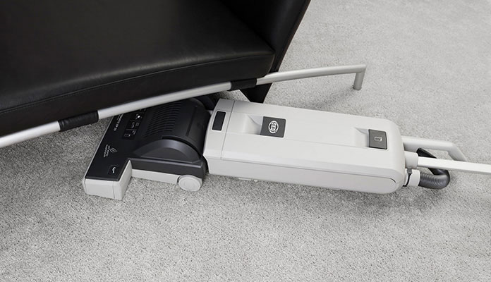SEBO AUTOMATIC XP 20 reinigt dank flacher Bauweise unter einem Möbelstück.