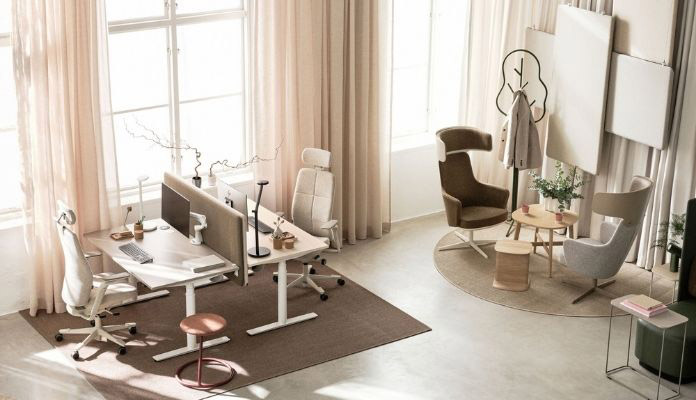 Bright, modern home office with two white desks, ergonomic chairs, and partitioned workstations in a sunlit room.